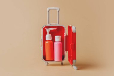 Sarı arka planda kırmızı çantada küçük bir losyon.