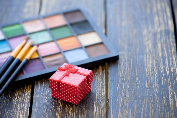 Подарочная коробка и кисти для макияжа с палитрой — стоковое фото