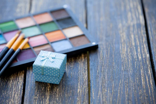 Geschenkbox und Pinsel für Make-up mit Palette — Stockfoto