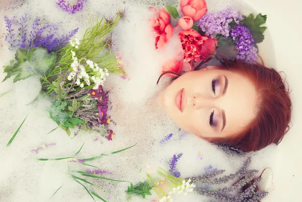 Fille dans la salle de bain avec des fleurs — Photo