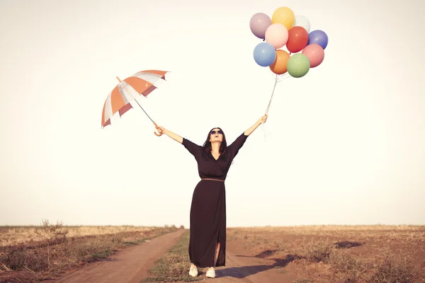 Meisje met veelkleurige ballonnen — Stockfoto