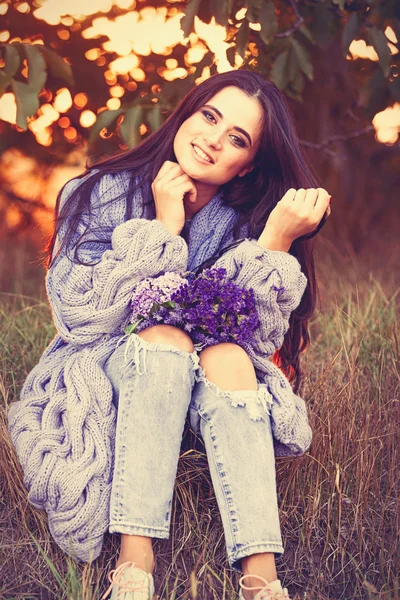 Meisje met bloemen in platteland — Stockfoto