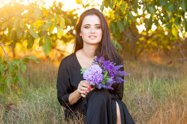 Meisje met bloemen in platteland — Stockfoto