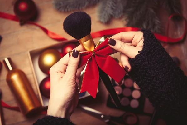 Female hands are wrapping cosmetics — Stock Photo, Image