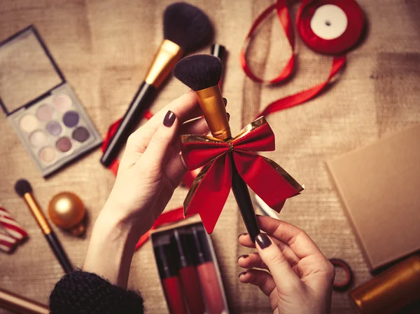 Ręce do pakowania kosmetyków w Boże Narodzenie prezenty — Zdjęcie stockowe