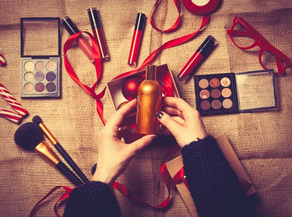 Les mains enveloppent les cosmétiques dans des cadeaux de Noël — Photo