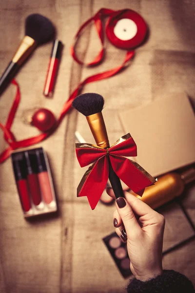 Les mains enveloppent les cosmétiques dans des cadeaux de Noël — Photo