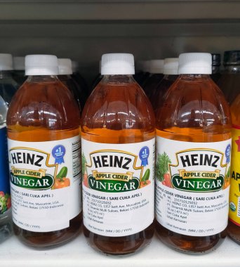 Süpermarket rafındaki üç şişe elma sirkesini kapat.