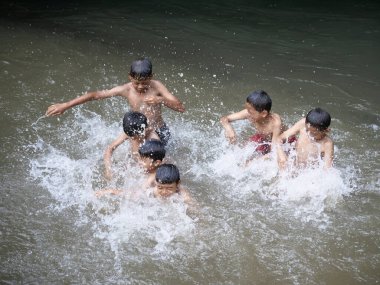 Erkekler 2 Ocak 2026 'da Endonezya' nın Jakarta şehrinde nehirde su sıçratıyor.