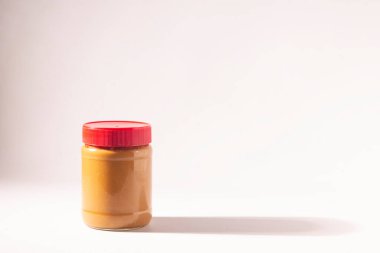 boş, beyaz zemin üzerine kırmızı kapaklı kavanoz