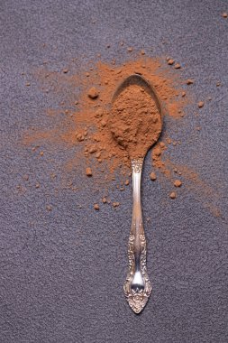 Siyah arka planda bir kaşık kahve.