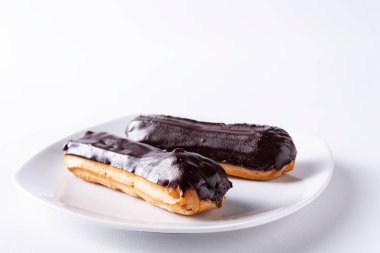 Beyaz arka planda kremalı çikolatalı pasta.