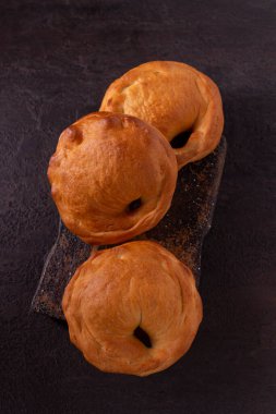Siyah arka planda taze pişmiş çörekler.