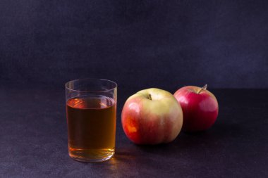 Meyve suyu ve olgun elmalarla dolu bardak