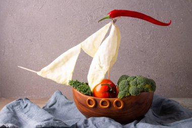 Gri arka planda poşette taze sebzeler..