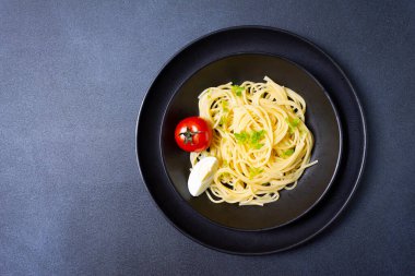 Spagetti domates sosu ve siyah arka plan üzerine fesleğen ile