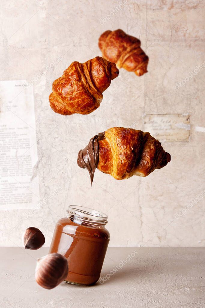 chocolate paste, croissants on vintage paper background flying food
