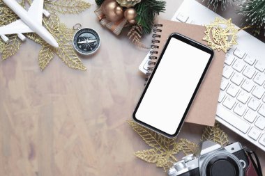 Yılbaşı için boş beyaz ekran akıllı telefonu ev ofis masasında tatil gezisi arka planı konsepti, düz açılı cep telefonu modeli, kamera, Xmas süslemeleri..