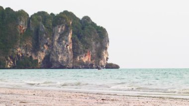 Tropik Sandy Beach Railay ya da Rai Leh West 'in arka planda kireçtaşı uçurumları, Krabi Eyaleti, Tayland. Soyut yaz tatili arka plan videosu beyaz kumlu güneşli tropik cennet plajı.