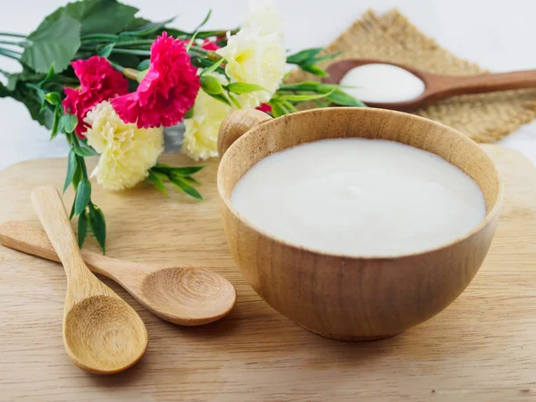 Yogur blanco, leche en taza de madera y cuchara de madera — Foto de Stock