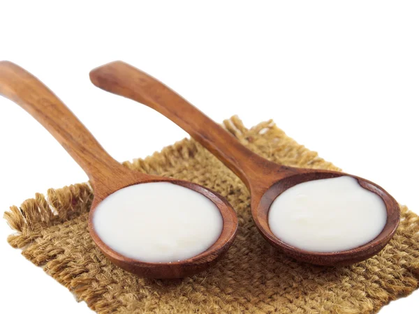 Yogur en cuchara de madera en saco de aislado — Foto de Stock