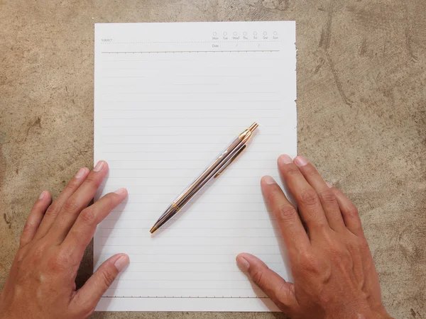 Hand hålla papper och penna på golvet — Stockfoto