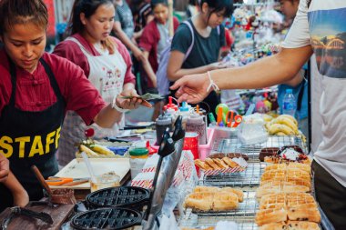 Kadın yemek yapıyor ve waffle satıyor