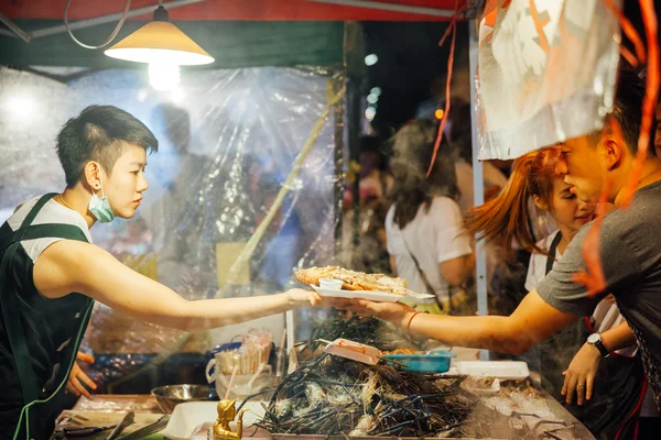 Mujer joven cocina y vende pescado y mariscos —  Fotos de Stock