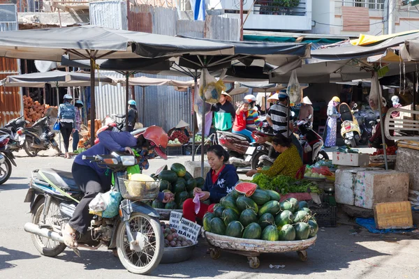 Mujer está vendiendo manzanas estrella y sandías en el mercado húmedo — Foto de Stock