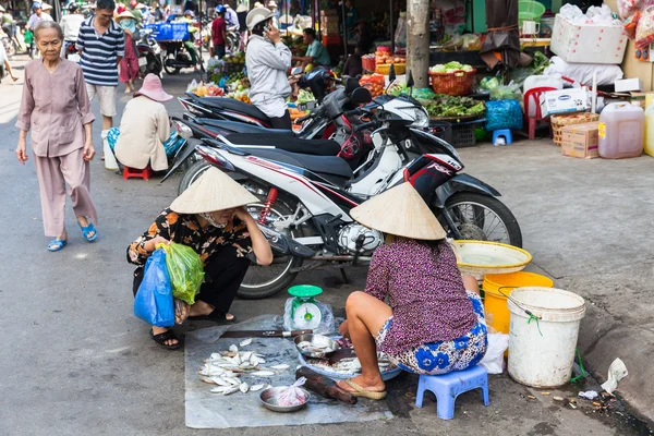 Vietnamese woman in traditional conical hat is selling fish at the wet market — Stock Photo, Image