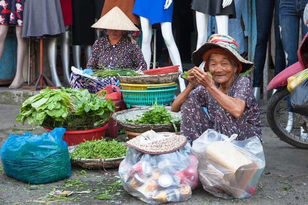 Vieja tomar un descanso para comer y descansar en la calle del mercado — Foto de Stock