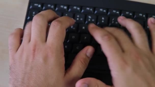 Plato de un mans manos escribiendo en el teclado negro — Vídeos de Stock