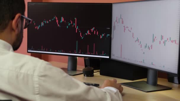 Obchodník zkoumá burzovní grafy na počítači — Stock video