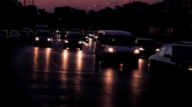 Akşam trafiği ve araba farları asfalta yansıyor