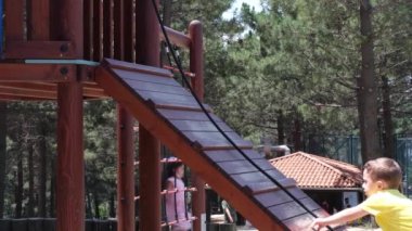 Tırmanan çocuk, oyun alanındaki tırmanma platformunda, beyaz çocuk