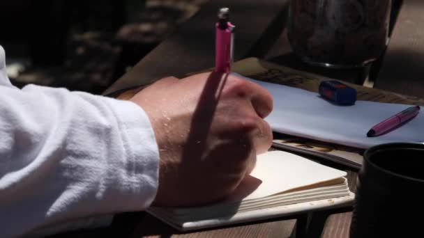 Mężczyzna Pisz, mężczyzna notuje w swoim notatniku w nocy, pisze notatki, zwolnione tempo — Wideo stockowe