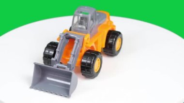 döner oyuncak, oyuncak inşaat makinesi beyaz ve yeşil arka planda döner