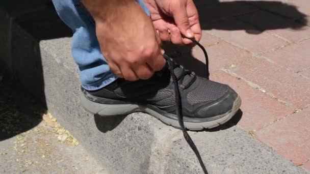 Atando cordones, atando los cordones de sus zapatillas, en el pavimento — Vídeos de Stock