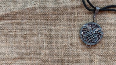 Tılsımı gümüşten yapılmış iki kurt şeklinde olan tuval arka plan. Fantezi, elfler, Viking, cüceler. El yapımı. El yapımı..