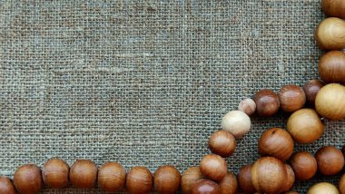 Tahta tespih, tuvalin üstünde. Çerçevenin sol tarafındaki kabataslak kumaş üzerindeki ahşap boncuklar. El yapımı..