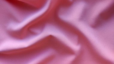 Pembe kumaş arka planda dalgalar yakın, ilginç dalgalı arkaplan, kumaşın üstündeki dalgaların üst görünümü, yumuşak buruşuk mat kumaş, gölge kumaş 