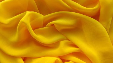 Sarı kumaş arkaplan, dalgalar yakın, ilginç dalgalı arkaplan, kumaş üzerindeki dalgaların üst görünümü, yumuşak kırışık kumaş, gölge kumaş 