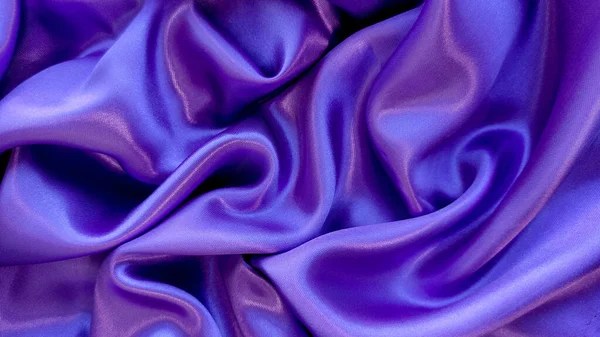 Purple fabric background with waves close-up, interesting wavy background, top view of waves on fabric, wrinkled fabric, original fabric