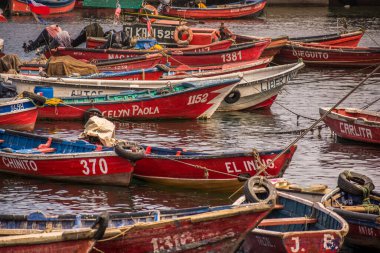 Red fishers empty boats anchored in Antofagastas harbour with different names and numbers and white and blue interior. Antofagasta, north Chile