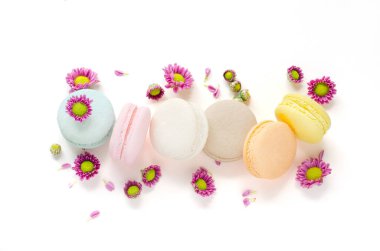 Beyaz arka planda küçük mor sevimli çiçekli bir grup lezzetli pastel tatlı makarna.