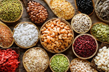 Sağlıklı ya da temiz besin maddeleri ya da tarım ürünleri konsepti için, çeşitli tür kuru organik tahıl ve tahıl tohumları koyu tonda ahşap kasede