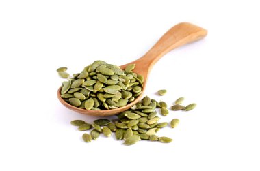 Kapalı organik balkabağı tohumu yığını beyaz arka planda tahta kaşıkta