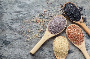 Arkaplanda tahta kaşıkta dört çeşit soya tohumu yığını var. Sağlıklı gıda veya tarım ürünleri konsepti için