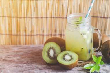 Dilimlenmiş taze kivi meyvesi ve cam sürahide meyve suyu yumuşak ve hafif arka planda grunge.