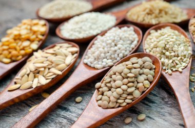 Kapalı organik mercimek tohumu yığını ahşap kaşıkla çeşitli mısır gevreği arka planında bulanık arkaplan ve grunge arka planda tahıl tohumu. Karbonhidrat ve sağlıklı besin maddeleri için.